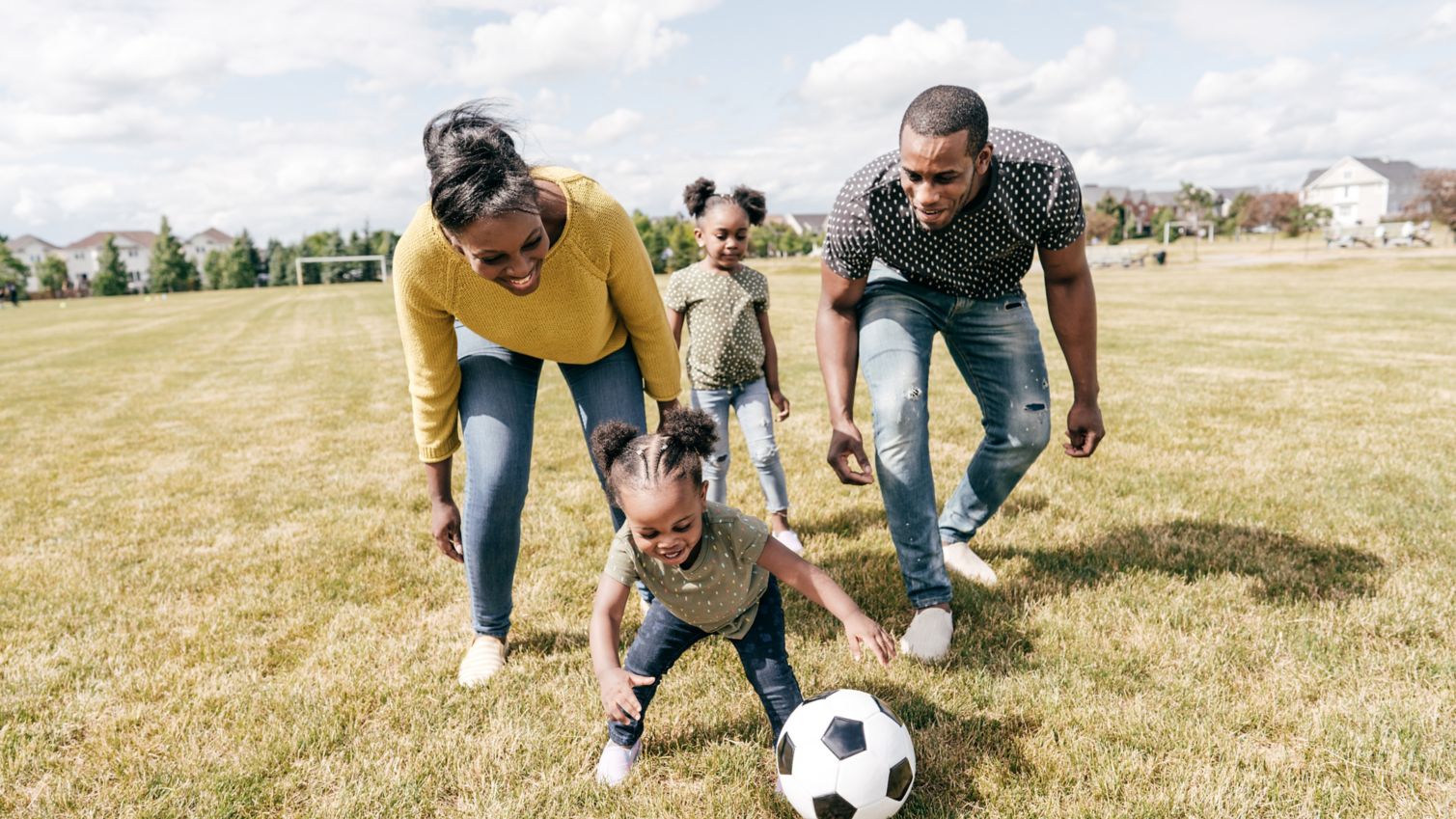 Mom and dad play outside with their daughters